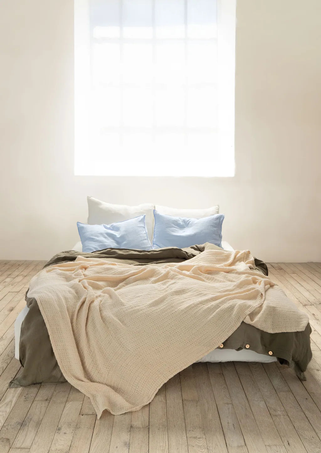 Soft neutral Vesta linen bedding with pale blue pillows